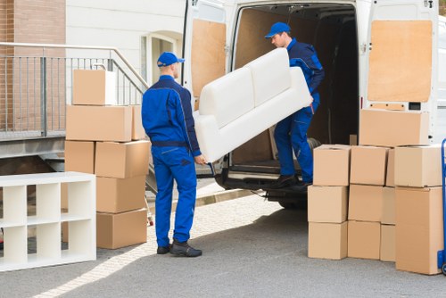 Removal workers loading furniture in Mileend